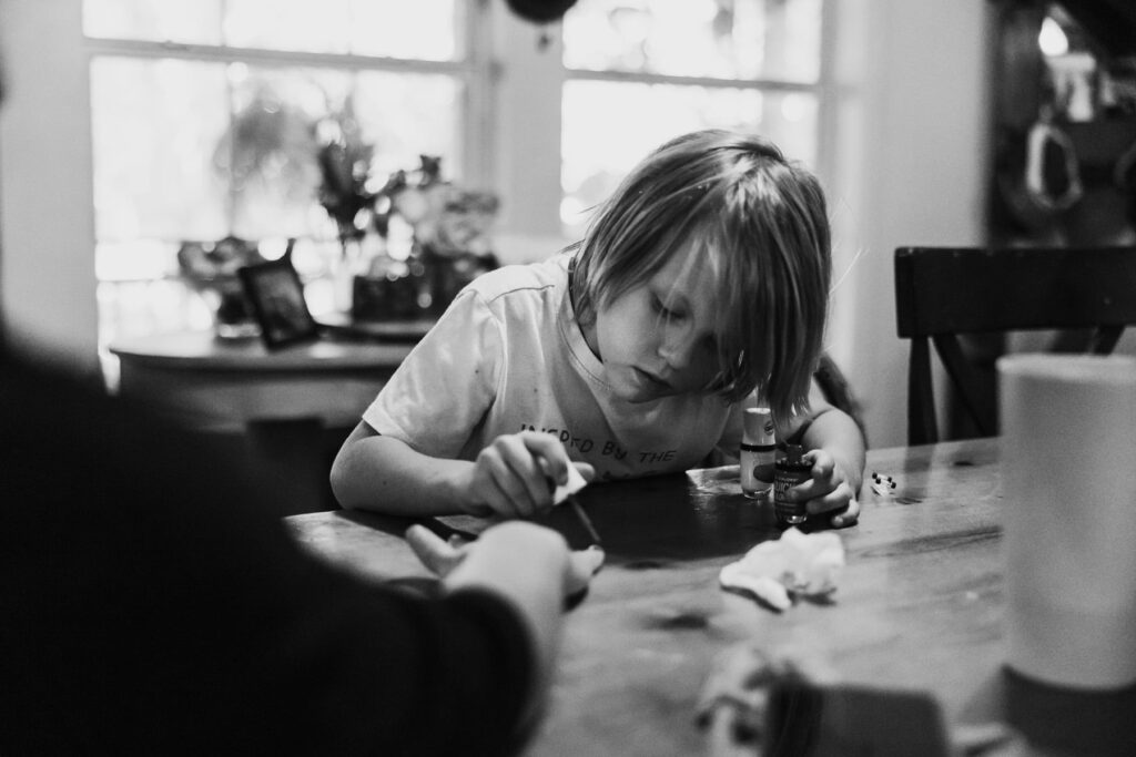 A young son painting his mothers nails, documentary style capture