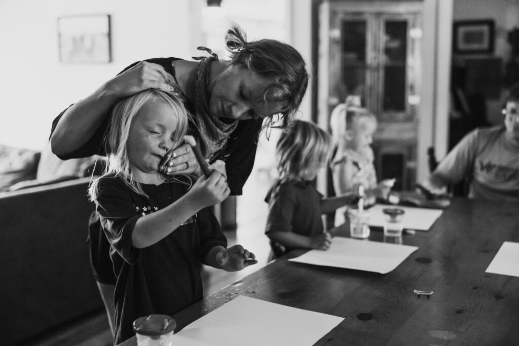 A mother wiping the face of her young son at the family table, image from a family documentary