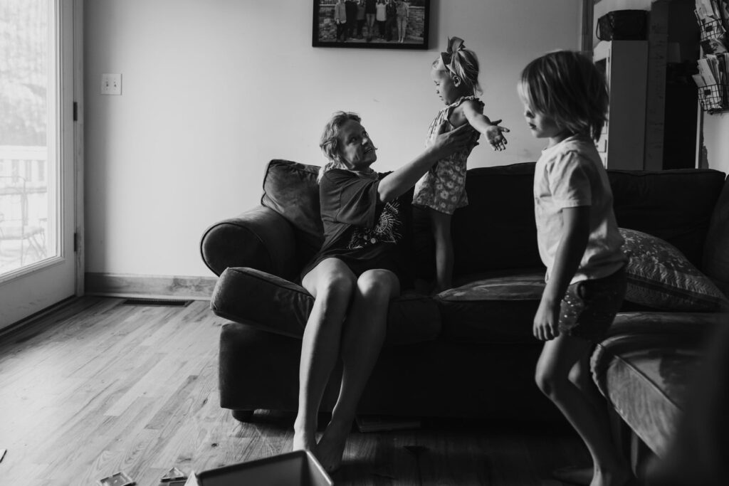 a young family playing on a couch during a lifestyle photo session