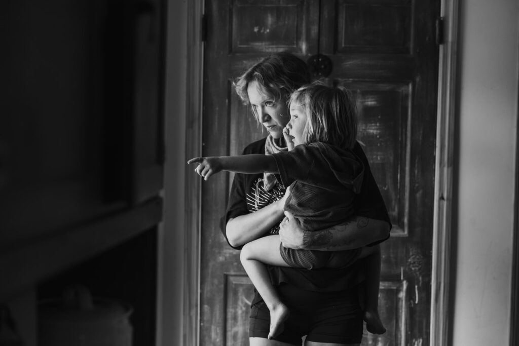 Mother holding her son at the front door