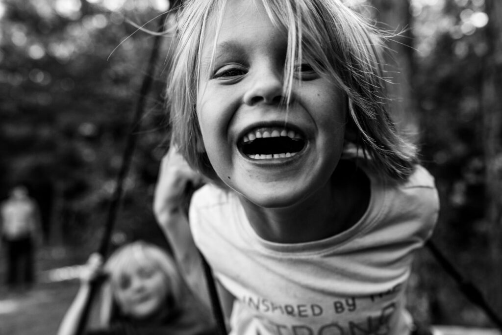 Close up of a young boy lit up with laughter, from a lifestyle candid session