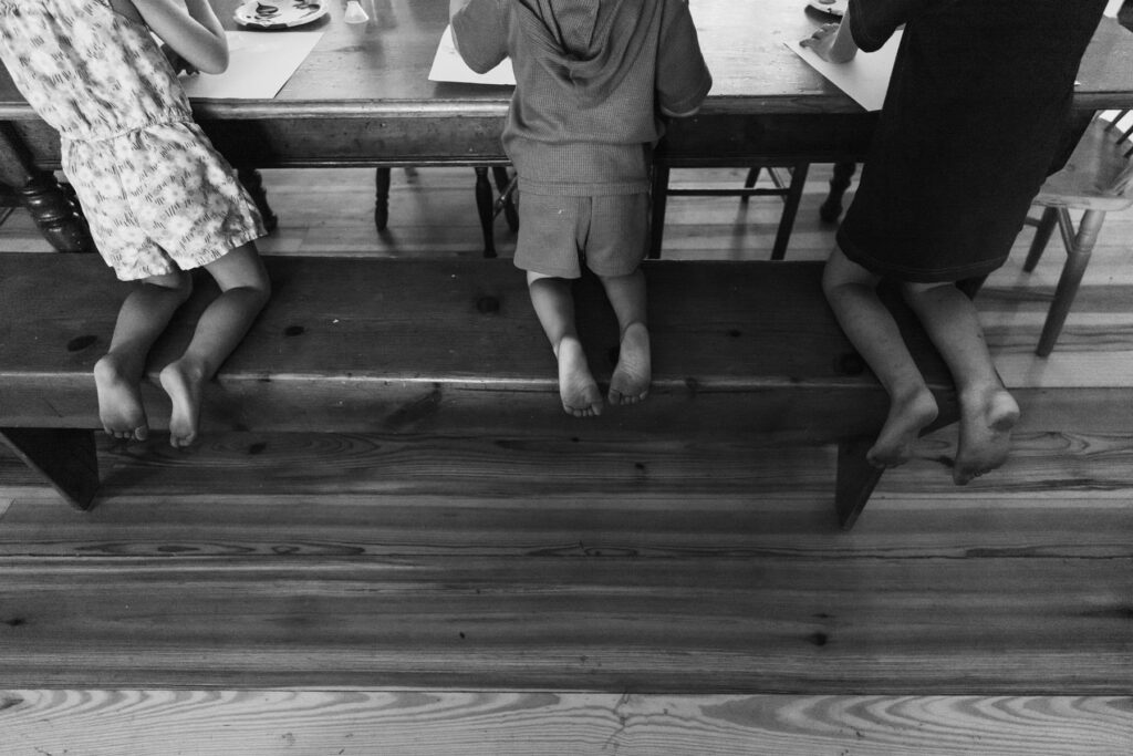 young feet dangling off a dining bench