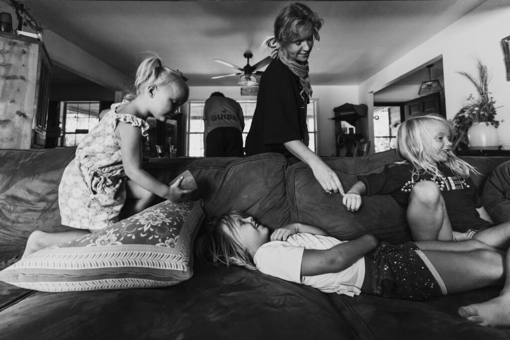 a young family playing on a couch during a candid family session