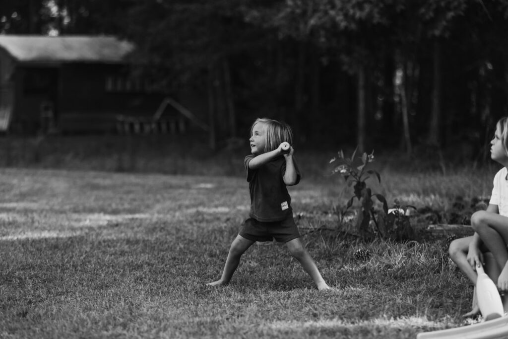 young kid playing baseball in the yard, candid capture