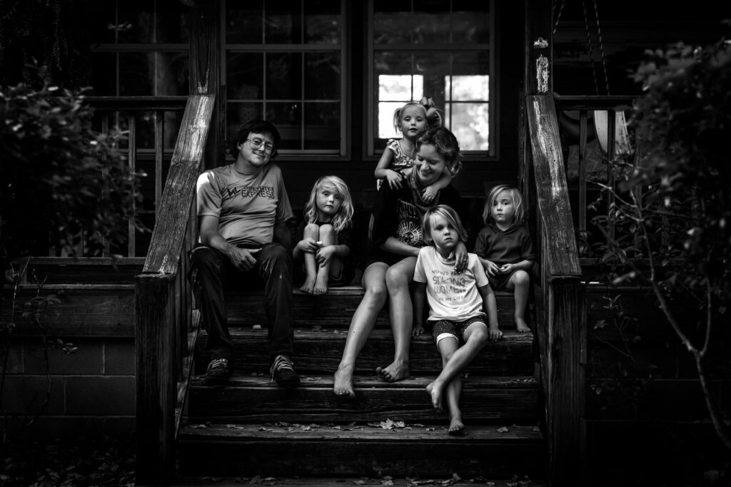 family gathered on front porch, black & white candid